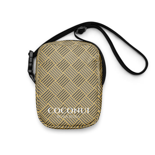 a bcrossbody bag with woven pendant pattern lay on a white background 